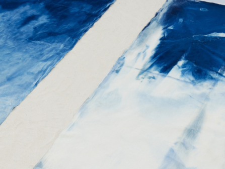 Abstract blue and white diagonal brushstrokes on a light background, forming geometric shapes and a painterly, icy look.